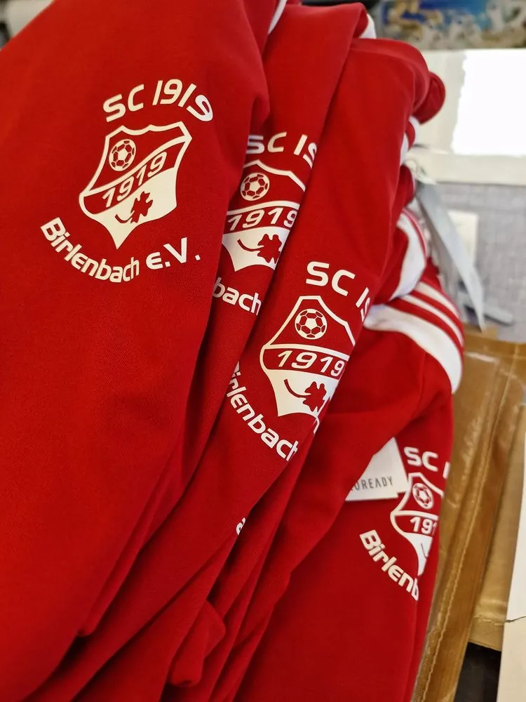 Rote Trainingsjacken mit Vereinswappen des SC 1919 Birlenbach
